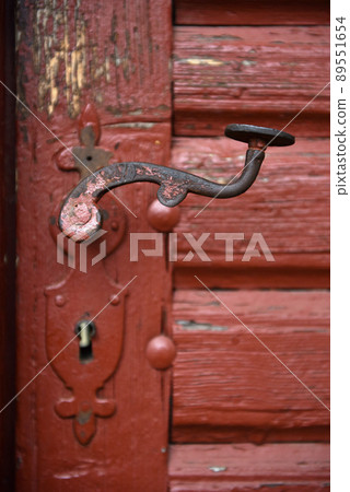 Ornamental vintage iron door handle on wooden door Ornamental vintage iron door handle on wooden door 89551654