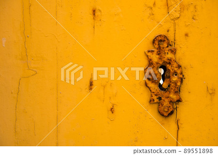 Rusty vintage keyhole on a yellow door Rusty vintage keyhole on a yellow door 89551898