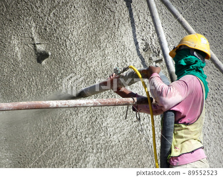 SELANGOR, MALAYSIA -MARCH 4: Construction workers are spraying liquid concrete onto the slope surface to form a retaining wall layer. It acts to prevent erosion on the slope surface. SELANGOR, MALAYSIA -MARCH 4: Construction workers are spraying liquid concrete onto the slope surface to form a retaining wall layer. It acts to prevent erosion on the slope surface. 89552523