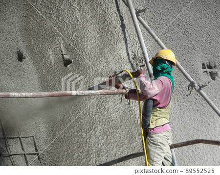 SELANGOR, MALAYSIA -MARCH 4: Construction workers are spraying liquid concrete onto the slope surface to form a retaining wall layer. It acts to prevent erosion on the slope surface. SELANGOR, MALAYSIA -MARCH 4: Construction workers are spraying liquid concrete onto the slope surface to form a retaining wall layer. It acts to prevent erosion on the slope surface. 89552525