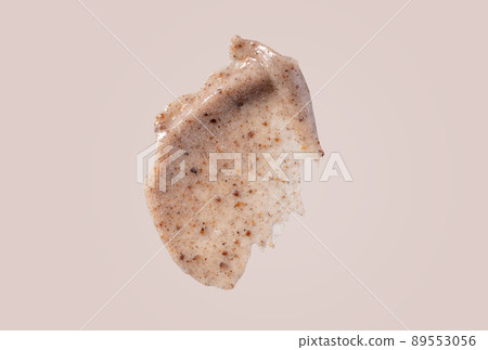 Scrub smear swatch isolated on beige background. Peeling cream smudge with exfoliating particles. Cosmetic skincare product with abrasive particle sample, gentle nude scrub texture. 89553056