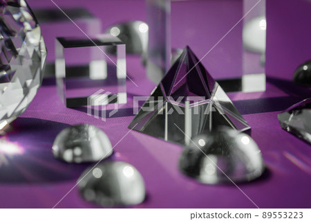 Crystal prism refracting light, magic crystals and pyramid, sphere and cube on purple background. Spiritual healing crystal practice. Feng Shui, good energy flow concept background.. Crystal prism refracting light, magic crystals and pyramid, sphere and cube on purple background. Spiritual healing crystal practice. Feng Shui, good energy flow concept background.. 89553223