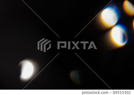 Blue light flare prism rainbow flares overlay effect on black background, light crossing crystals, prismatic sun catcher reflections rays. Abstract blurred colourful lens flare bokeh on dark 89553302