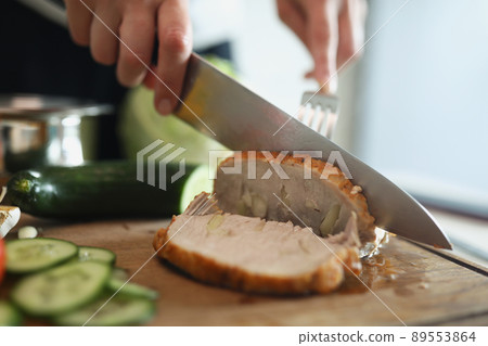 Person cutting homemade ham, delicious aromatic meat with garlic pieces Person cutting homemade ham, delicious aromatic meat with garlic pieces 89553864
