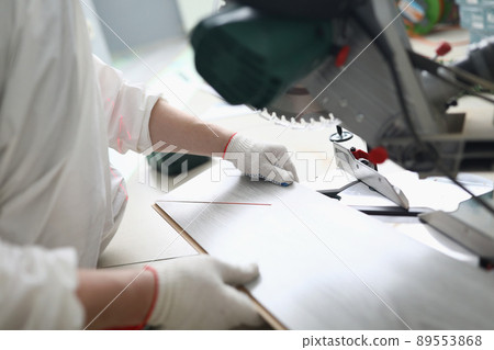 Foreman holding wooden plank, put bar under electric saw, going to cut wooden plank Foreman holding wooden plank, put bar under electric saw, going to cut wooden plank 89553868