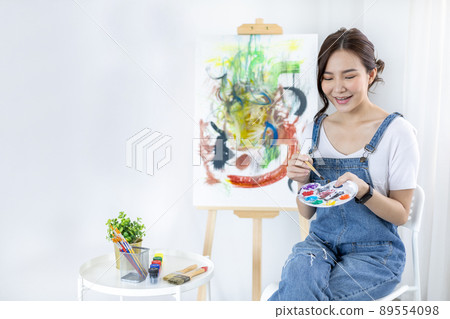 Female artist painting on canvas, Artist studio interior, Draw with watercolor, Drawing supplies , Painting and creativity, Use a brush to draw a pattern by stripes, Artwork, Using Paint Brush. 89554098