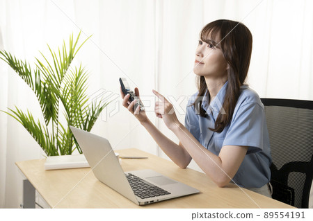 A woman who thinks with a smartphone at the office A woman who thinks with a smartphone at the office 89554191