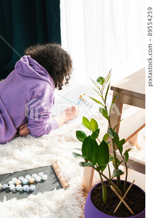 The adult woman painting by numbers indoors 89554259