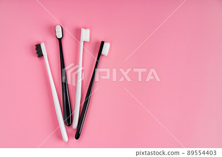Fashionable toothbrush with soft bristles. Popular toothbrushes. Hygiene trends. Kit of toothbrushes on pink background 89554403