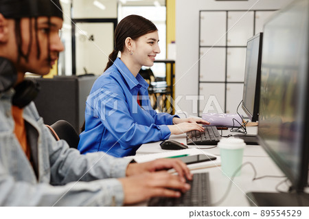 Smiling Girl using Computer in College Smiling Girl using Computer in College 89554529