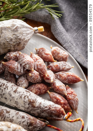 Traditional sausage with white mold. Dried pork salami on plate. 89554579