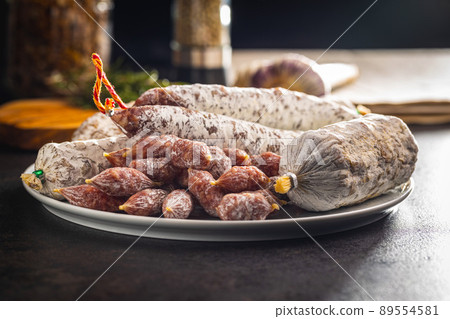 Traditional sausage with white mold. Dried pork salami on plate. 89554581