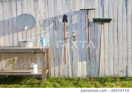 Garden tools on the background of a white fence. The concept of agricultural, garden utensils. Outdoor Gardening tools and Accessories. High quality photo Garden tools on the background of a white fence. The concept of agricultural, garden utensils. Outdoor Gardening tools and Accessories. High quality photo 89554719