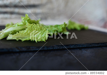 green lettuce on black slate background. 89554802