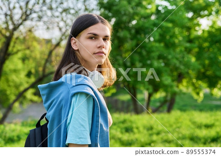 Outdoor portrait of handsome student guy with backpack looking at camera, copy space 89555374