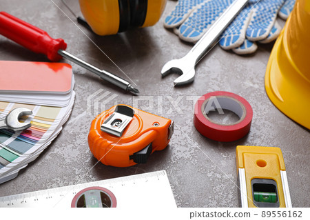 Many different construction tools on grey marble table 89556162