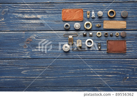 Flat lay composition with garment accessories for jeans on blue wooden background. Space for text 89556362