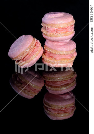 Three pink macarons on glossy black background Three pink macarons on glossy black background 89556464