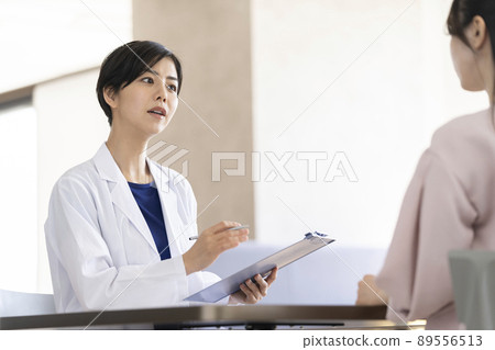 Image of a female doctor / medical worker in a white coat listening to the other person's story Image of a female doctor / medical worker in a white coat listening to the other person's story 89556513