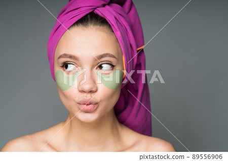 with a towel wrapped around her head with nude shoulders pasted patches under her eyes with a towel wrapped around her head with nude shoulders pasted patches under her eyes 89556906