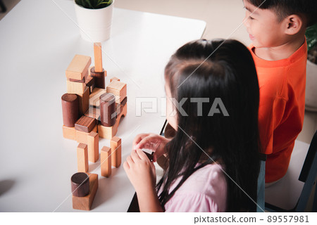 Children boy and girl playing with constructor wooden block building 89557981