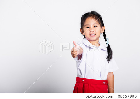 Asian adorable toddler smiling happy wear student thai uniform red skirt show thumb up finger Asian adorable toddler smiling happy wear student thai uniform red skirt show thumb up finger 89557999