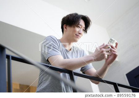 A man staring at a smartphone against the sun A man staring at a smartphone against the sun 89559176