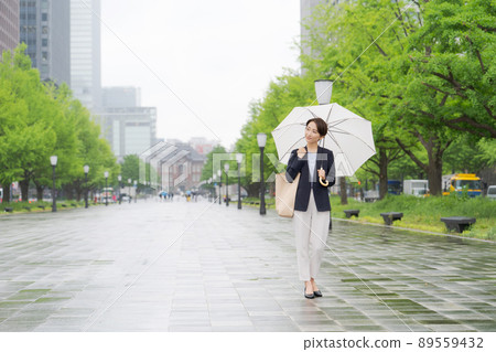 A woman walking with an umbrella 89559432