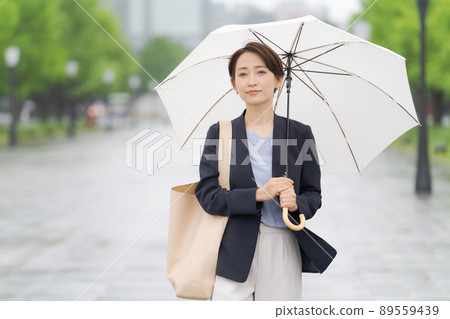A woman walking with an umbrella A woman walking with an umbrella 89559439