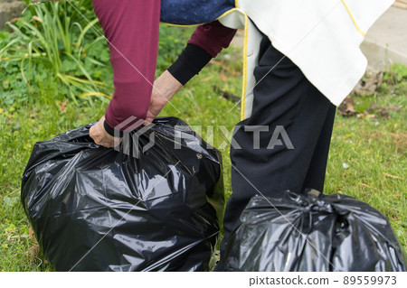 Senior woman tying a trash bag 89559973