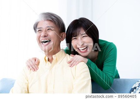 Parent and child of middle father and young daughter relaxing in the living room Parent and child of middle father and young daughter relaxing in the living room 89560405
