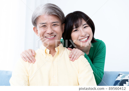 Parent and child of middle father and young daughter relaxing in the living room Parent and child of middle father and young daughter relaxing in the living room 89560412