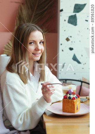 blond girl cube formed dessert with cream, raspberry, blueberry and marshmallow topping closeup photo blond girl cube formed dessert with cream, raspberry, blueberry and marshmallow topping closeup photo 89561820