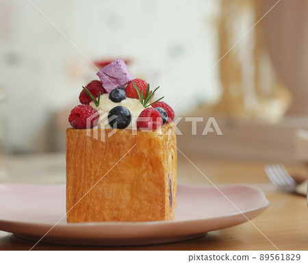 cube formed dessert with cream, raspberry, blueberry and marshmallow topping closeup photo 89561829