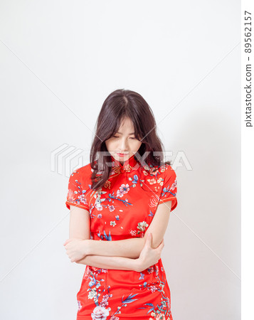 Young asian woman wearing traditional cheongsam qipao dress with hands on chest over isolated white background. Young asian woman wearing traditional cheongsam qipao dress with hands on chest over isolated white background. 89562157