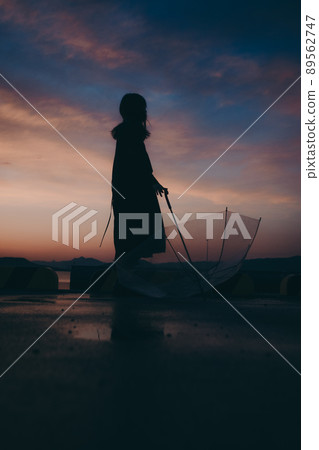 Female silhouette and beautiful sunset sky Female silhouette and beautiful sunset sky 89562747
