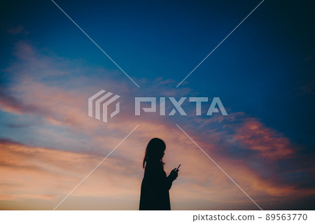 Female silhouette and beautiful sunset sky 89563770