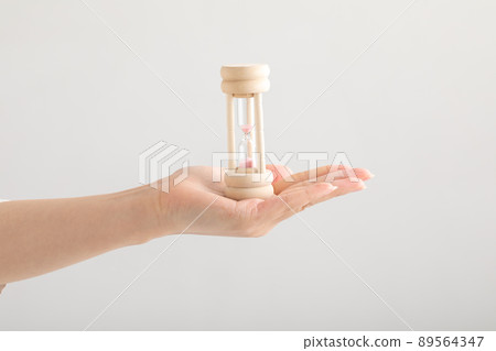 Hands of a woman with an hourglass Hands of a woman with an hourglass 89564347