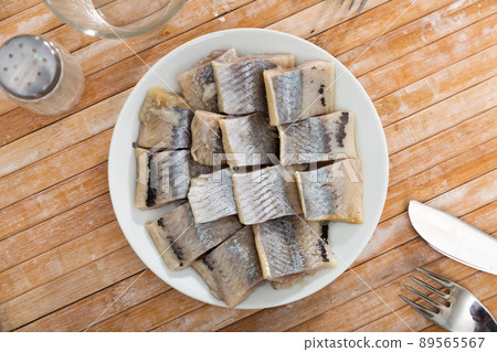 Salted pickled herring fish served on a ceramic plate Salted pickled herring fish served on a ceramic plate 89565567