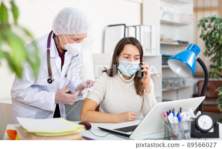Doctor making vaccine injection to businesswoman Doctor making vaccine injection to businesswoman 89566027