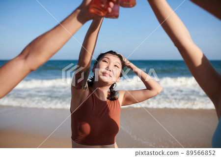 Woman Drinking with Friends on Beach 89566852