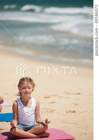 Little Girl Meditating on Beach Little Girl Meditating on Beach 89566872