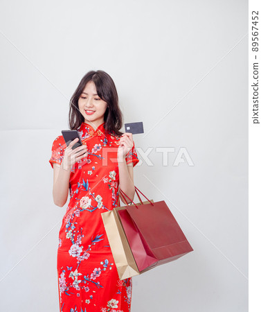 由傳統旗幟書寫,白底女子,一目前書寫,信用卡,智慧型手機使用,購物袋。 由傳統旗幟書寫,白底女子,一目前書寫,信用卡,智慧型手機使用,購物袋。 89567452
