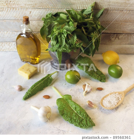 Ingredients for making pesto sauce, basil leaves, olive oil, garlic, salt, cheese and citruses on the kitchen table  89568361