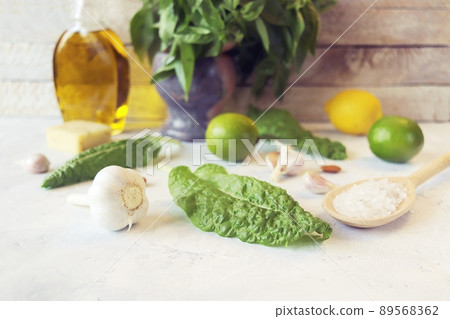 Ingredients for making pesto sauce, basil leaves, olive oil, garlic, salt, cheese and citruses on the kitchen table Ingredients for making pesto sauce, basil leaves, olive oil, garlic, salt, cheese and citruses on the kitchen table 89568362