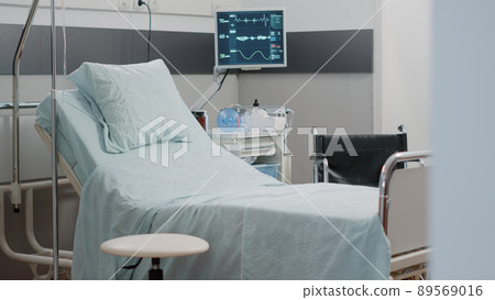 Nobody in hospital ward bed with medical equipment and heart rate monitor for reanimation. Empty intensive care room with instruments, IV drip bag and oxygen tube for healthcare. Nobody in hospital ward bed with medical equipment and heart rate monitor for reanimation. Empty intensive care room with instruments, IV drip bag and oxygen tube for healthcare. 89569016