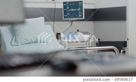 Empty hospital ward for healthcare recovery at facility. Nobody in reanimation room with heart rate monitor, bed, bottle of pills and oxygen tube for medical treatment. Space for health Empty hospital ward for healthcare recovery at facility. Nobody in reanimation room with heart rate monitor, bed, bottle of pills and oxygen tube for medical treatment. Space for health 89569017