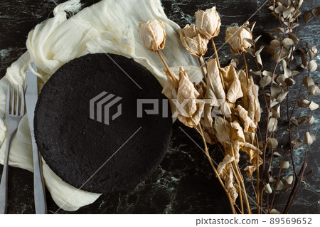 Black plate and dried flowers of white roses 89569652