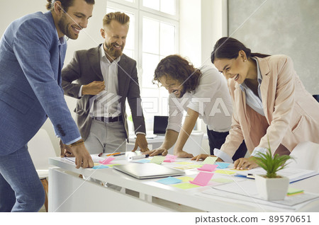 Smiling gen Z coworkers brainstorm discuss ideas in office Smiling gen Z coworkers brainstorm discuss ideas in office 89570651