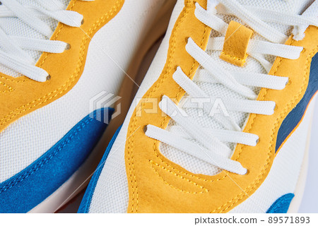 Casual sneakers on yellow background, creative minimalism Casual sneakers on yellow background, creative minimalism 89571893